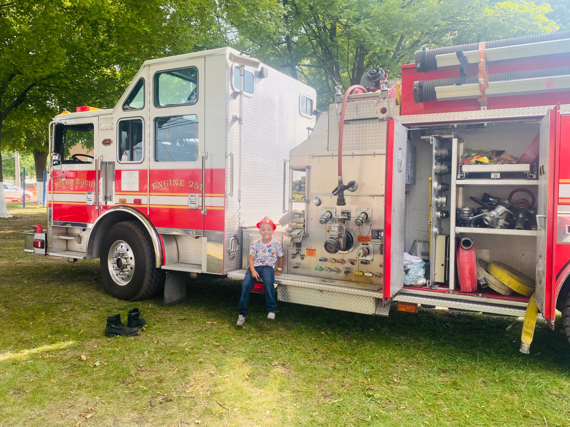 A young child exploring a fire truck at a Detroit Riverfront Rangers community event